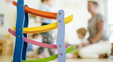Eine Erzieherin spielt in einer Kindertagesstätte mit einem Kind. Foto: Uwe Anspach/dpa/Archivbild