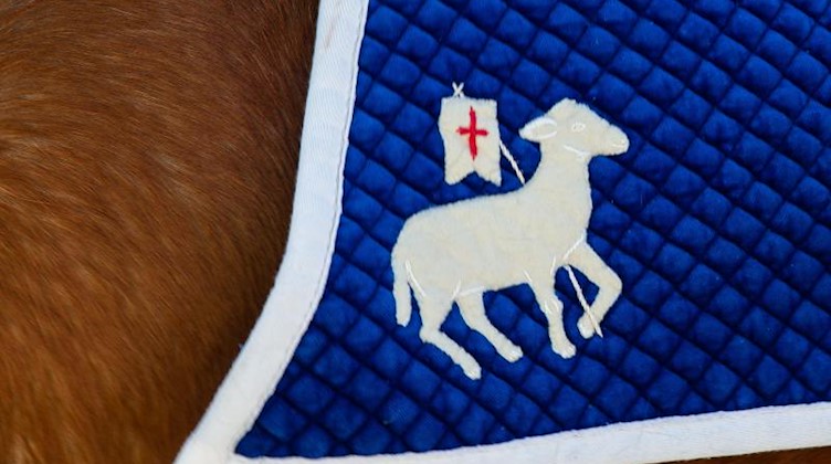 Die Osterreiter haben unter dem Sattel eine Reiterdecke mit einem Lamm aufgestickt. Foto: Daniel Schäfer/dpa-Zentralbild/dpa/Symbolbild
