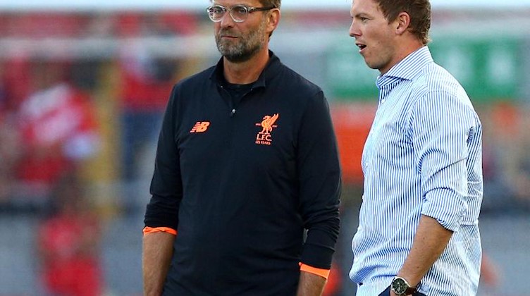 Liverpools Trainer Jürgen Klopp (l) und Leipzigs Trainer Julian Nagelsmann. Foto: Dave Thompson/AP/dpa
