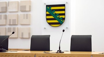 Ein Landeswappen des Freistaates Sachsen hängt in einem Gerichtssaal im Oberverwaltungsgericht. Foto: Arno Burgi/dpa-Zentralbild/dpa