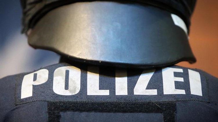 Ein Polizeibeamter in Schutzkleidung. Foto: Fredrik von Erichsen/dpa