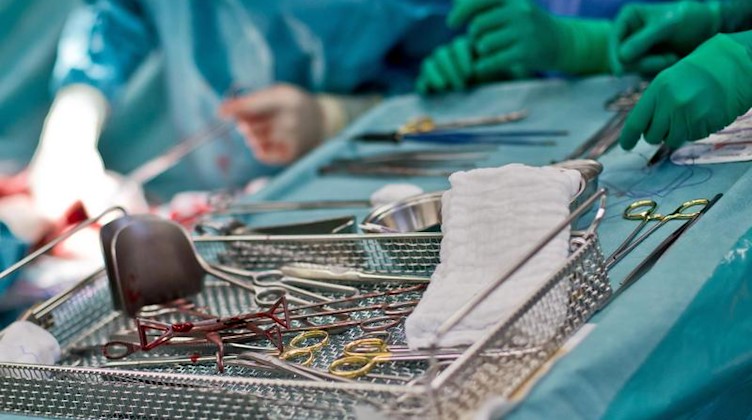 Chirurgische Instrumente liegen während einer Kaiserschnittentbindung auf einem Tisch. Foto: Daniel Karmann/dpa
