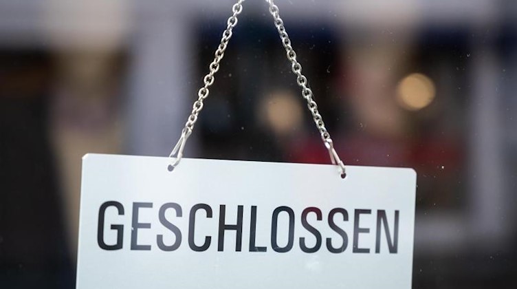 In einem Schaufenster hängt ein Schild mit der Aufschrift «geschlossen». Foto: Christophe Gateau/dpa