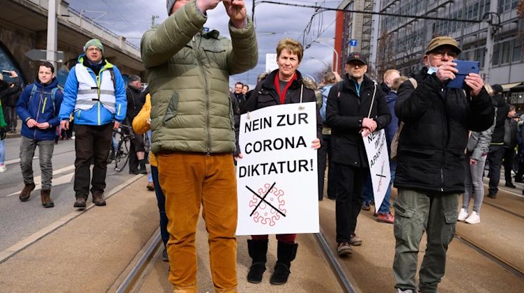 Eine Demonstrantin hält bei einer Kundgebung in Dresden ein Schild mit der Aufschrift «Nein zur Corona Diktatur». Foto: Sebastian Kahnert/dpa-Zentralbild/dpa/Archivbild