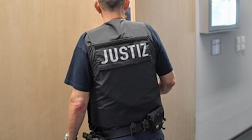 Ein Justizmitarbeiter schließt die Tür zu einem Verhandlungssaal. Foto: Patrick Pleul/zb/dpa/Symbolbild/Archivbild