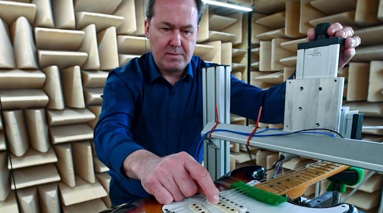 Holger Schiema, Geschäftsführer des Instituts für Musikinstrumentenbau Zwota, richtet eine E-Gitarre ein. Foto: Hendrik Schmidt/dpa-Zentralbild/dpa/Archivbild