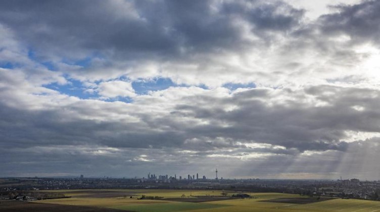 Nur vereinzelt können sich die Sonnenstrahlen einen Weg durch die ansonsten dichte Wolkendecke bahnen. Foto: Boris Roessler/dpa/Symbolbild