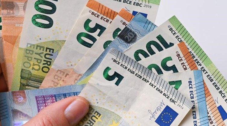 ILLUSTRATION: Eine Frau hält Eurobanknoten in ihren Händen (gestellte Aufnahme). Foto: Patrick Pleul/dpa-Zentralbild/dpa/Illustration