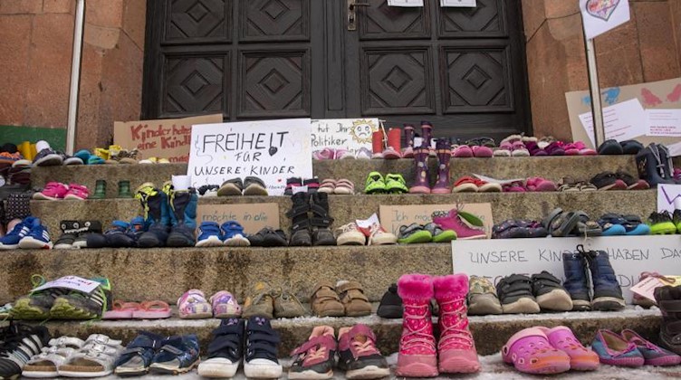 Zahlreiche Schuhe stehen vor dem Eingang des Rathauses In Thalheim im Erzgebirge. Foto: Bernd März/B&S/dpa