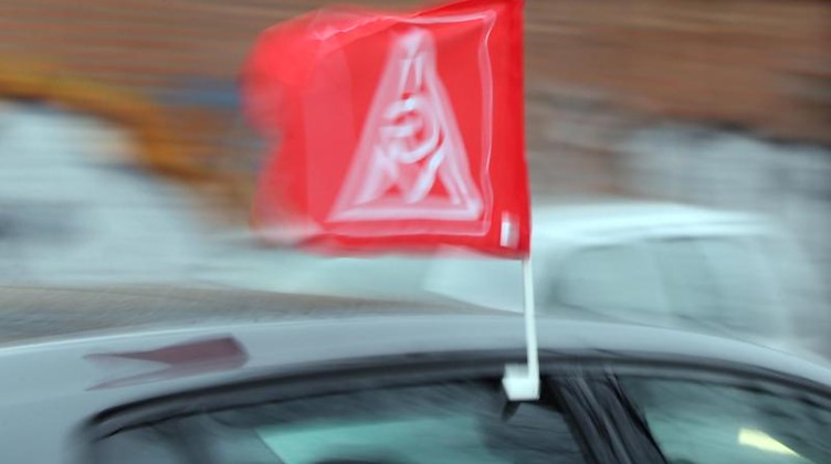 Eine Fahne mit dem Logo der Gewerkschaft IG Metall weht an einem Auto. Foto: Wolfgang Kumm/dpa/Archivbild