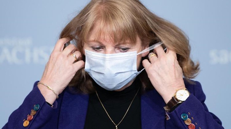Sachsens Gesundheitsministerin Petra Köpping nimmt zu Beginn einer Pressekonferenz ihren Mund-Nasen-Schutz ab. Foto: Sebastian Kahnert/dpa-Zentralbild/dpa/archivbild