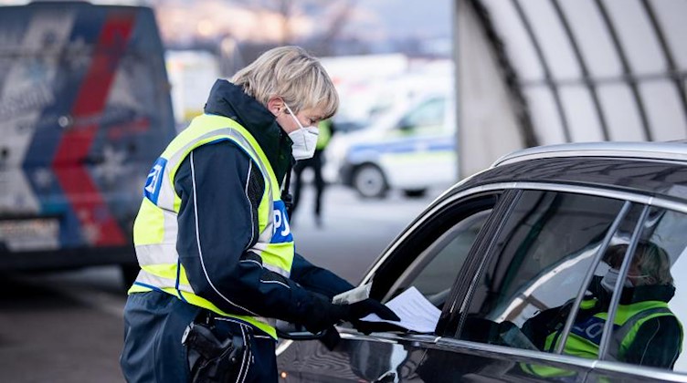 Eine Bundespolizistin kontrolliert die Dokumente eines Reisenden. Foto: Matthias Balk/dpa/Archivbild