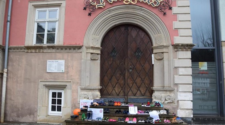 Aus Protest gegen die Schließung von Schulen in der Corona-Pandemie haben Eltern Kinderschuhe vor dem Eingang des Rathauses abgestellt. Foto: Ulrike Müller/Stadtverwaltung Eisenach/dpa