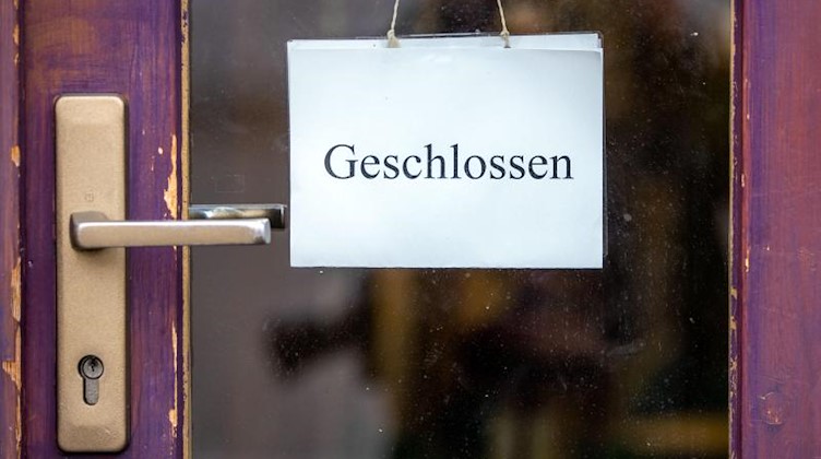 Ein Schild mit der Aufschrift «Geschlossen» an der Tür eines Geschäfts in der Schweriner Innenstadt. Foto: Jens Büttner/dpa-Zentralbild/dpa/Archivbild