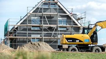 Ein eingerüsteter Rohbau eines Einfamilienhauses steht in einem Neubaugebiet. Foto: Hauke-Christian Dittrich/dpa/Symbolbild