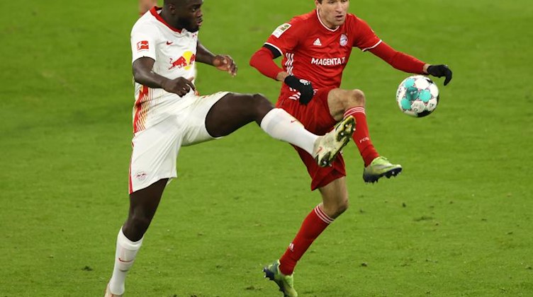 Dayot Upamecano (l) von RB Leipzig und Thomas Müller in Aktion. Foto: Alexander Hassenstein/Getty Images Europe/Pool/dpa/Archivbild