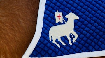 Die Osterreiter haben unter dem Sattel eine Reiterdecke mit einem Lamm aufgestickt. Foto: Daniel Schäfer/dpa-Zentralbild/dpa/Archivbild