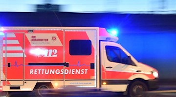 Ein Rettungswagen ist mit eingeschaltetem Blaulicht im Einsatz. Foto: Boris Roessler/dpa/Archivbild