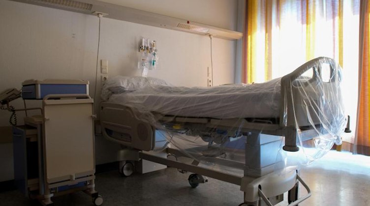 Ein mit Folie überzogenes Bett steht in einem Krankenhauszimmer. Foto: Federico Gambarini/dpa/Archivbild