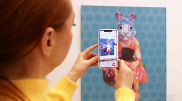 Geschäftsführerin Patrizia Meyn zeigt, wie ein Gemälde mithilfe einer App lebendig wird. Foto: Claudia Drescher/dpa-Zentralbild/dpa/Archivbild
