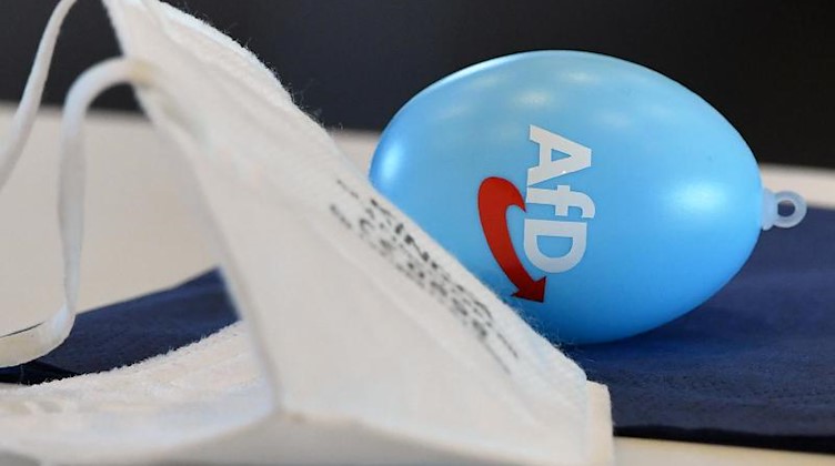 Eine FFP2-Maske und ein Osterei mit AfD-Logo liegt auf dem Tisch eines AfD-Abgeordneten. Foto: Martin Schutt/dpa-Zentralbild/dpa