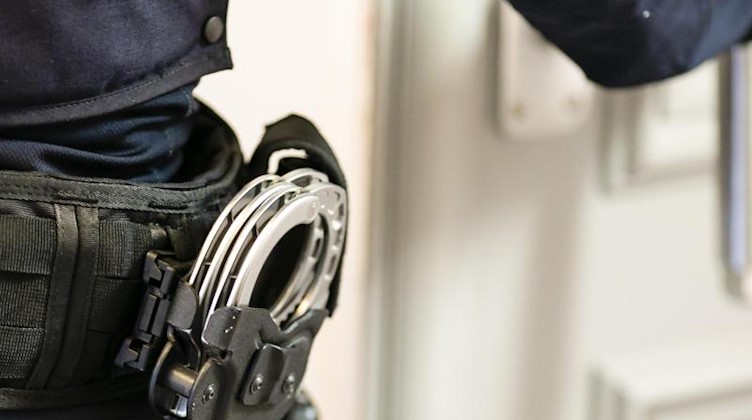 Handschellen sind an einem Gürtel eines Justizvollzugsbeamten befestigt. Foto: Frank Molter/dpa
