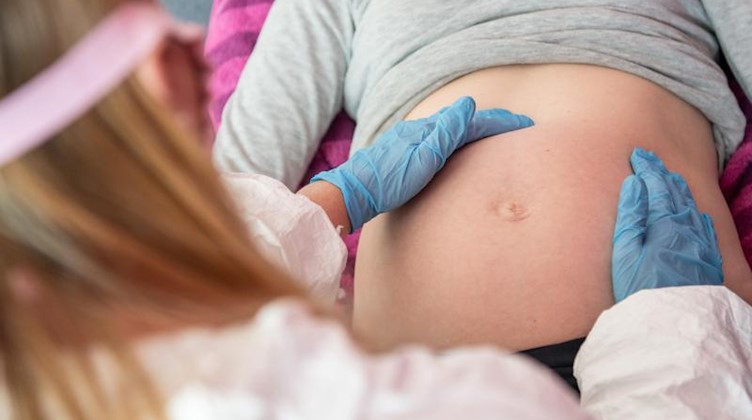 Eine Hebamme untersucht eine schwangere Frau. Foto: Caroline Seidel/dpa/Symbolbild