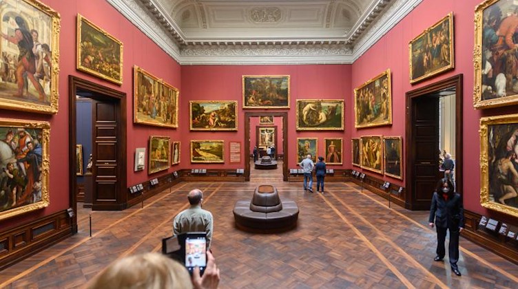 Besucher sehen sich die Ausstellung in der Gemäldegalerie Alte Meister an. Foto: Robert Michael/dpa-Zentralbild/dpa/Archivbild