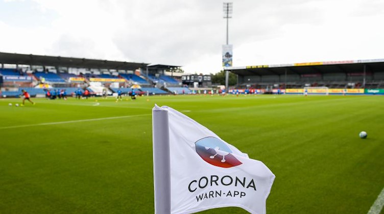 Auf einer Eckfahne in einem Stadion ist das Logo der Corona Warn-App der Bundesregierung aufgedruckt. Foto: Gregor Fischer/dpa/Archivbild