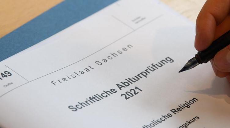 Schriftliche Abiturprüfung liegen auf dem Tisch eines Schülers. Foto: Robert Michael/dpa-Zentralbild/dpa