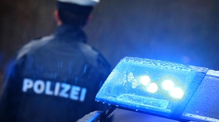 Ein Polizist steht vor einem Streifenwagen. Foto: Karl-Josef Hildenbrand/dpa/Symbolbild
