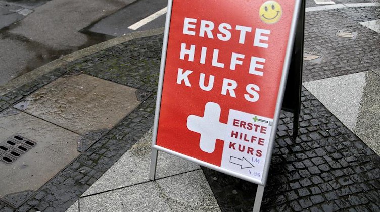 Ein Schild mit der Aufschrift «Erste Hilfe Kurs» steht auf einem Gehweg. Foto: Jan Woitas/dpa-Zentralbild/dpa/Archivbild