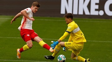 Der Ball von Leipzigs Stürmer Alexander Sörloth wird von Stuttgarts Torwart Gregor Kobel abgewehrt. Foto: Odd Andersen/AFP-Pool/dpa