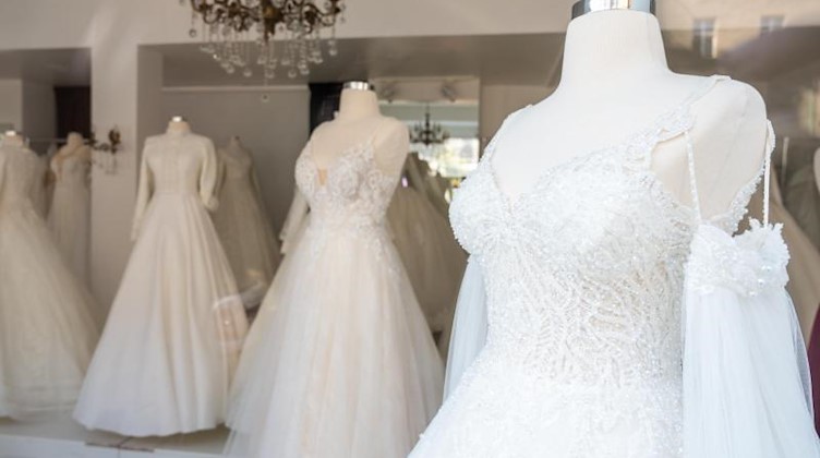 Schaufensterpuppen mit Hochzeitskleidern stehen in einem Brautmodengeschäft. Foto: Christophe Gateau/dpa/Symbolbild
