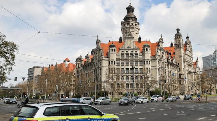 Ein Polizeifahrzeug fährt vor dem Neuen Rathaus über den Ring. Foto: Jan Woitas/dpa-Zentralbild/dpa