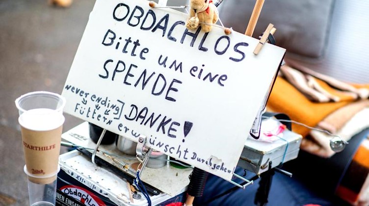 Ein Schild mit der Aufschrift „Obdachlos - bitte um eine Spende - danke!“. Foto: Hauke-Christian Dittrich/dpa/Archivbild