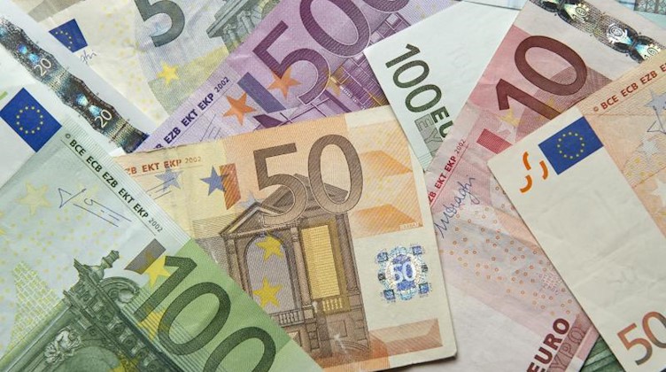 Zahlreiche Euro-Banknoten liegen auf einem Tisch. Foto: Daniel Reinhardt/dpa