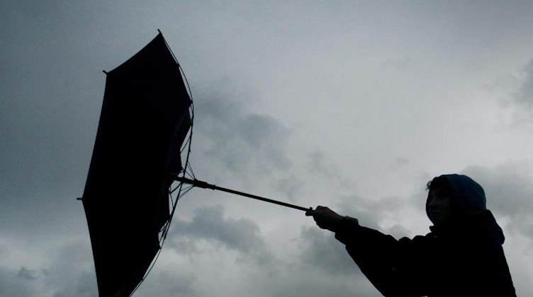 Der Regenschirm eines Spaziergängers wird von einer Windböe erfasst. Foto: picture alliance / Karl-Josef Hildenbrand/dpa/Symbolbild