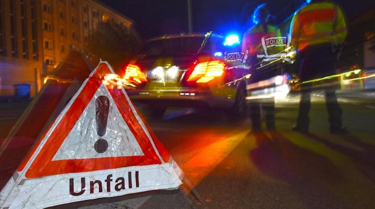 Ein Warndreieck steht neben einem Polizeifahrzeug auf der Straße. Foto: Patrick Seeger/dpa/Symbolbild