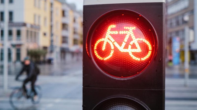 Ein Radfahrer steht an einer roten Ampel. Foto: Ole Spata/dpa/Symbolbild