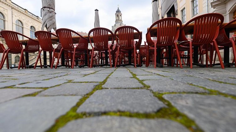 Tische und Stühle sind in Dresden vor einem Restaurant auf dem Neumarkt aufgestellt. Foto: Robert Michael/dpa-Zentralbild/dpa/Archivbild