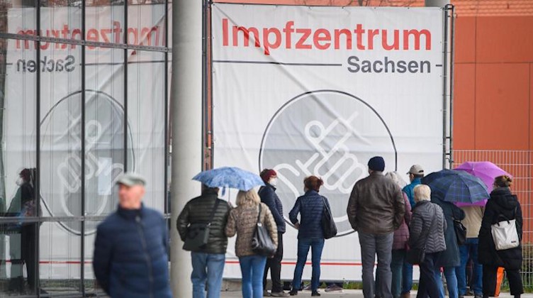 Menschen warten vor dem Impfzentrum an der Messe Dresden. Foto: Robert Michael/dpa-Zentralbild/dpa/Archivbild