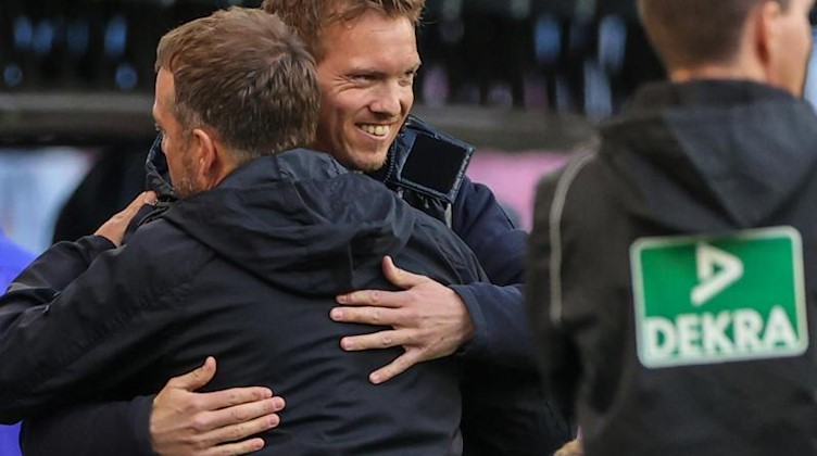Münchens Trainer Hansi Flick und Leipzigs Trainer Julian Nagelsmann umarmen sich. Foto: Jan Woitas/dpa-Zentralbild/dpa/archivbild