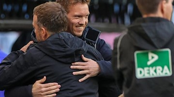 Münchens Trainer Hansi Flick und Leipzigs Trainer Julian Nagelsmann umarmen sich. Foto: Jan Woitas/dpa-Zentralbild/dpa/archivbild