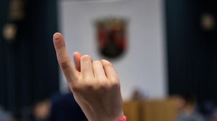 Eine Schülerin streckt den Finger nach oben. Foto: Andreas Arnold/dpa/Symbolbild