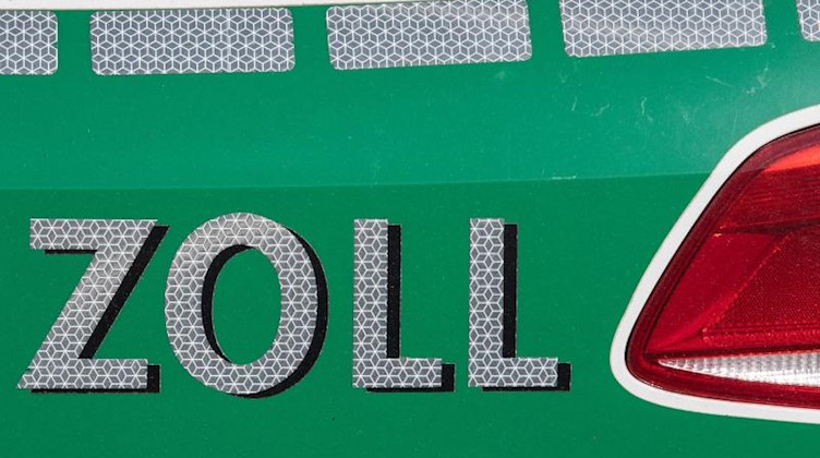 Ein Streifenwagen der Zoll-Beamten steht während einer Razzia am Einsatzort. Foto: Boris Roessler/dpa/Archivbild