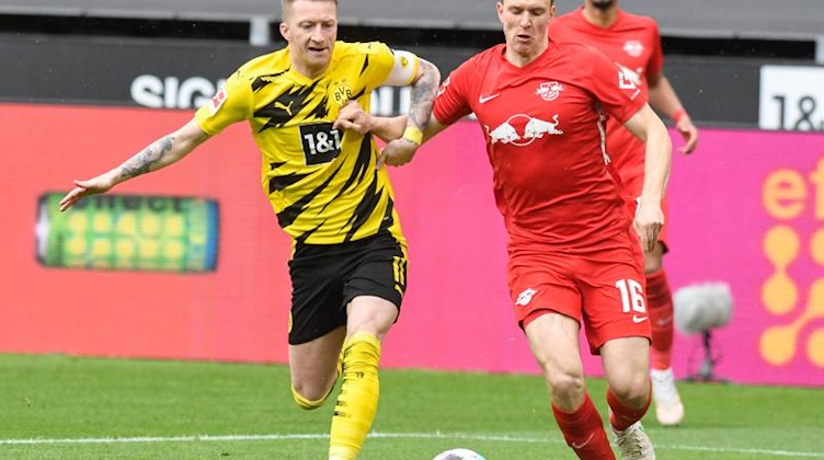 Leipzigs Abwehrspieler Lukas Klostermann (r) im Duell mit Dortmunds Mittelfeldspieler Marco Reus. Foto: Bernd Thissen/dpa/Archivbild