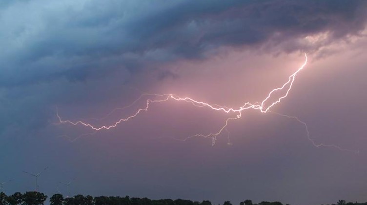 Ein Blitz erhellt den Abendhimmel über einem Feld. Foto: Patrick Pleul/dpa-Zentralbild/ZB/Symbolbild