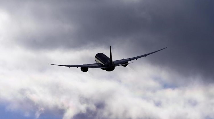 Ein Flugzeug fliegt vor einem bewölkten Himmel. Foto: Soeren Stache/dpa-Zentralbild/ZB/Symbol