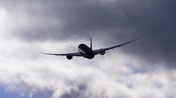 Ein Flugzeug fliegt vor einem bewölkten Himmel. Foto: Soeren Stache/dpa-Zentralbild/ZB/Symbol